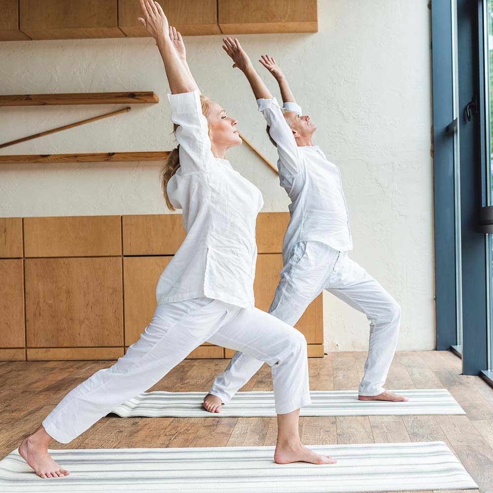 barefoot-sporty-senior-couple-practicing-yoga-at-h-GCRR59Q.jpg